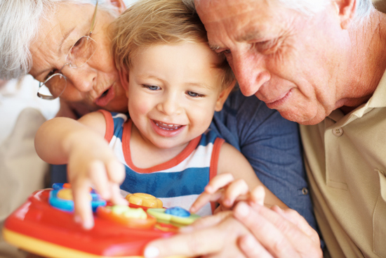 Closeup of boy playing a toy with his grandparents